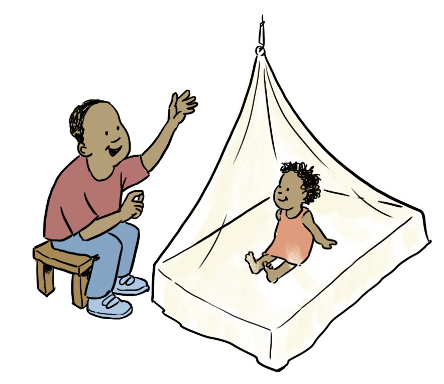 A small child in a pink shirt is sitting on a bed under a mosquito net as their parent sits outside telling them a story.