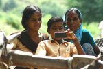 HP Child with Sister and Mother looking at a mobile in India