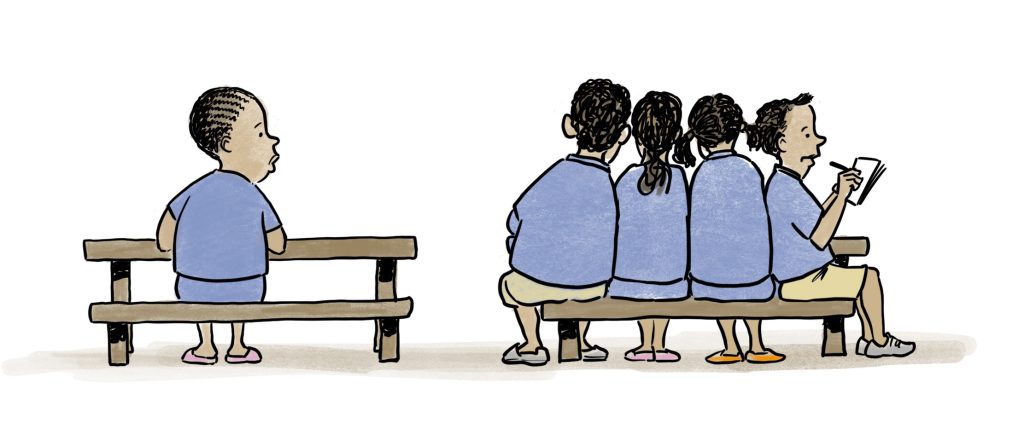 A child looks over from her desk to four people bunched up at desk instead of sharing hers.